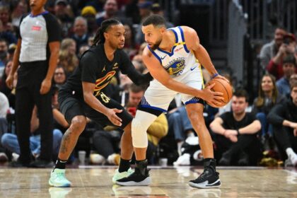 Darius Garland of the Cleveland Cavaliers guards Stephen Curry in the Cavs' NBA victory ov