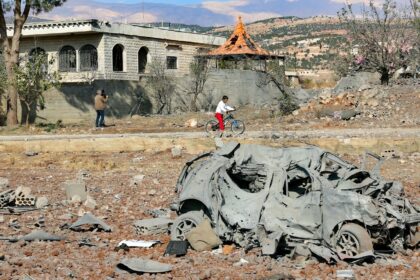 A destroyed car lies among debris a day after Israeli air strikes targeted the Lebanese vi