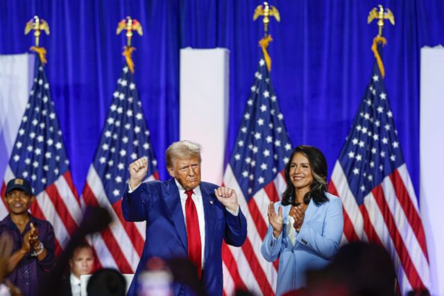 Donald Trump and former US Representative Tulsi Gabbard react during a town hall meeting i