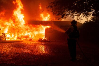 A firefighter attempts to control the blaze burning a house in Camarillo, California on No