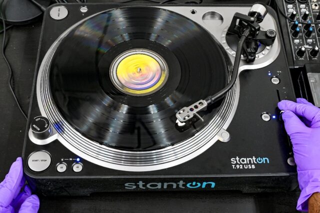 A freshly pressed vinyl record is tested for quality at the Samanvii Digimedia Art and Sol