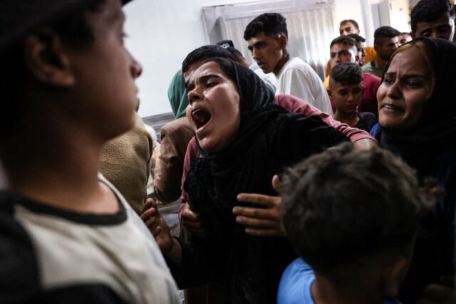 A Palestinian woman who lost relatives in an Israeli strike reacts after seeing their bodi