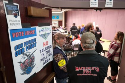 People look on as the Boeing Machinist union tallies votes on the latest Boeing contract o