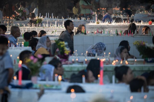 People light candles and pray for their relatives during the annual observance of All Sain