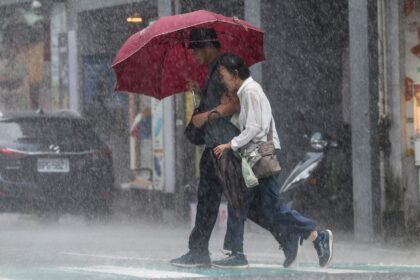 People walk along a street in heavy rain due to Super Typhoon Kong-rey in Keelung, Taiwan,