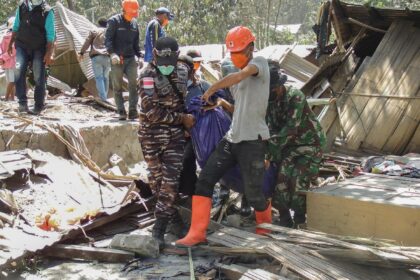 Rescuers carry away victims of a volcanic eruption in eastern Indonesia