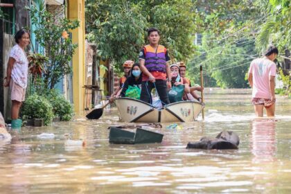 Rescuers ferry stranded residents from their flooded houses at a village in the Philippine