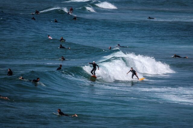 Surfers ride and paddle their boards at Maroubra Beach in Sydney last month