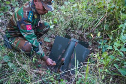 A Ta'ang National Liberation Army (TNLA) member looks at a Myanmar military unexploded ord