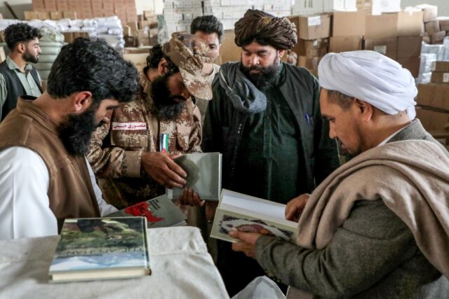 Taliban government personnel evaluate books imported from Iran to Afghanistan at a customs