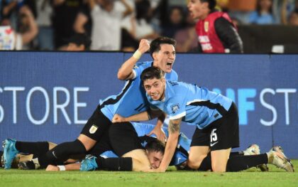 Uruguay's midfielder #05 Manuel Ugarte (bottom) celebrates with teammates after scoring hi