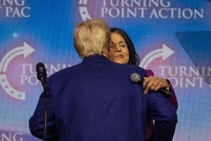 US President-elect Donald Trump embraces former US Representative Tulsi Gabbard, whom he h