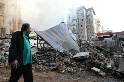 A man walks past the rubble of a building levelled by an Israeli air strike in Beirut's so