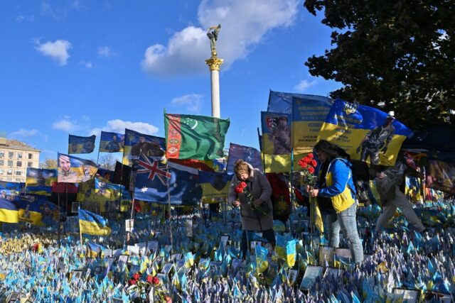 Women lay flowers in tribute to fallen Ukrainian soldiers at a makeshift memorial in Kyiv