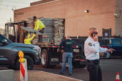 Workers unload fencing from a truck at the Maricopa County Election and Tabulation Center