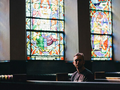 man sitting in church pew