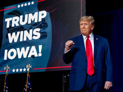 Republican presidential candidate former President Donald Trump takes the stage at a caucu