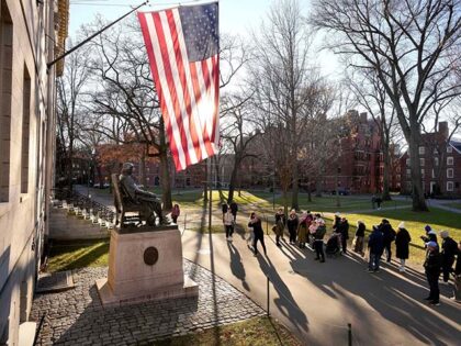 eople take photos near a John Harvard statue, left, on the Harvard University campus, Jan.