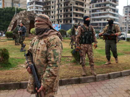 Fighters affiliated with Syria's new administration stand guard on the streets of Syr