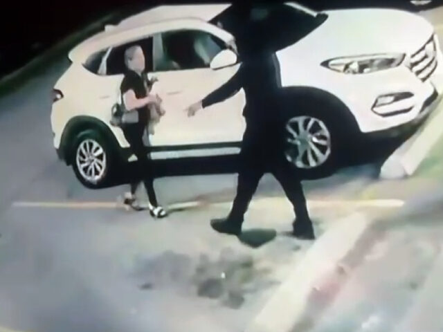 A suspect holds a woman at gunpoint in Brownsville during a carjacking. (Credit: Brownsvil