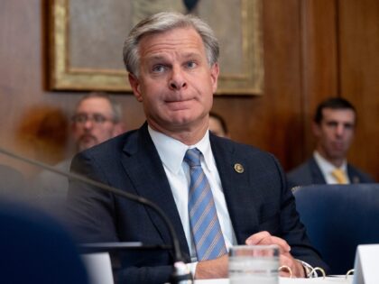 FBI Director Christopher Wray listens at the beginning of a meeting of the Justice Departm