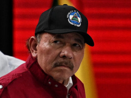 Nicaragua's President Daniel Ortega (R) looks on during the opening session of the XX