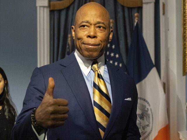 New York City Mayor Eric Adams gestures as he leaves a press conference at City Hall follo