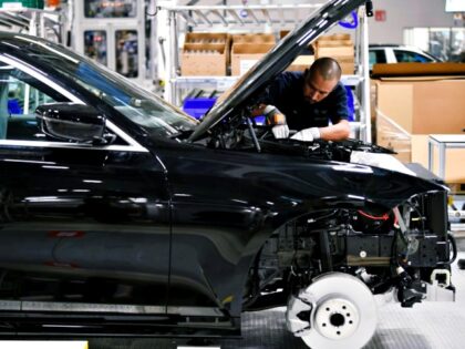 A BMW's employee is pictured working on a BMW car assembley process in a guided visit