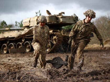 TOPSHOT - Soldiers carry a snatch block back to their recovery vehicle after winching a st