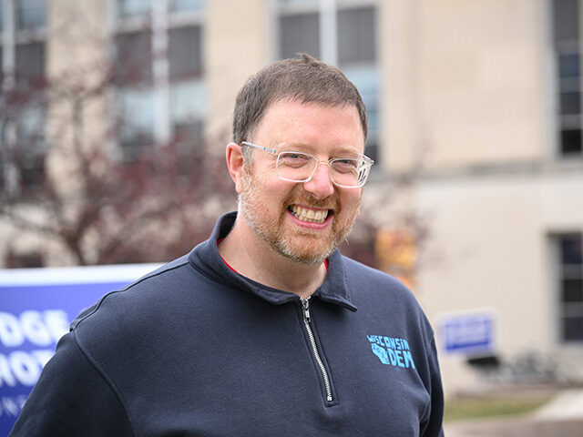 Chair of Wisconsin Democratic Party Ben Wikler and his dog pumpkin greet attendees during