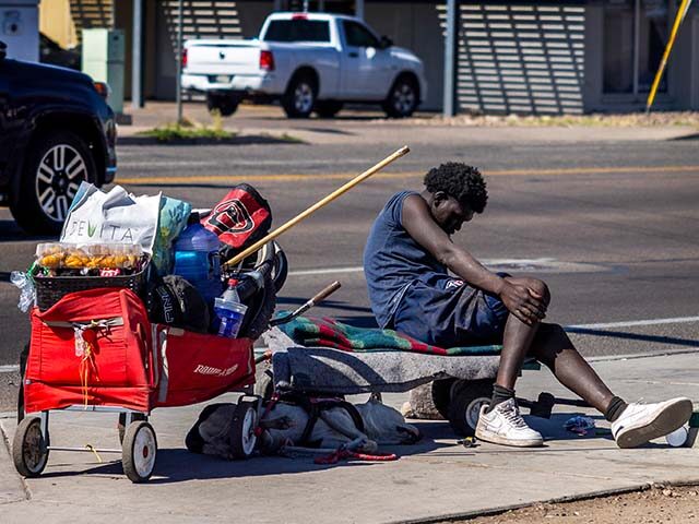 A homeless man is slumped over on a city bench in Phoenix on April 16, 2024 in Phoenix, Ar