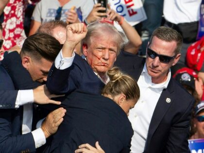 Republican candidate Donald Trump is seen with blood on his face surrounded by secret serv