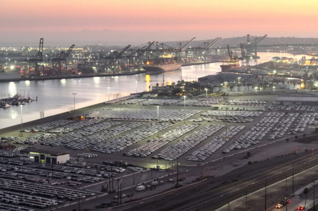 WILMINGTON, CALIFORNIA - DECEMBER 04: An aerial view of newly imported cars parked at the