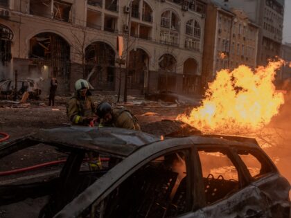 Ukrainian firefighters try to extinguish a fire on the site of a Russian missile attack in