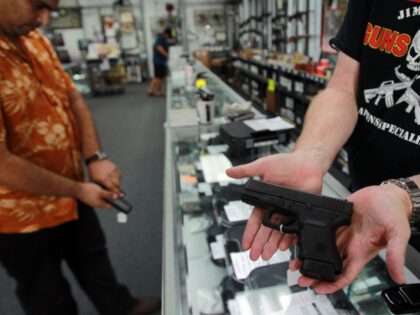 Joe Hall, weapons specialist at Jim Pruett's Gun's & Ammo, holds a Glock hand gun which th