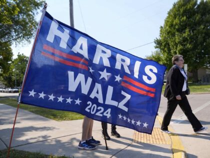 A supporter walks past a flag at a vendor stand before the arrival of Democratic president