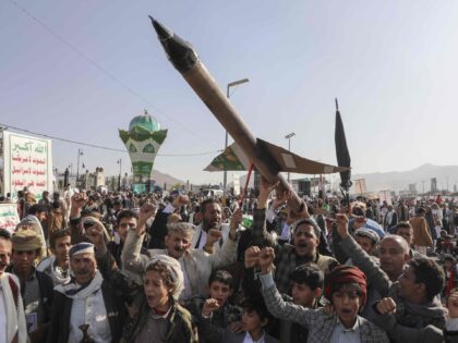 Houthi supporters carry a mock rocket and chant slogans during an anti-Israel rally in San