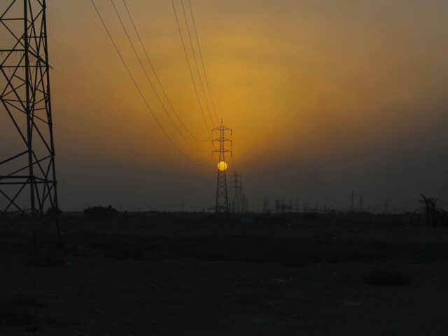 The sun sets behind the transmission lines of electric power from Iran to Iraq in Basra, I