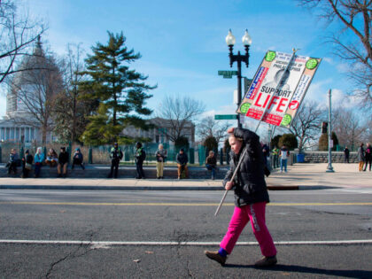 A young girl and pro-life activists marches with a placards and chant in front of the US S