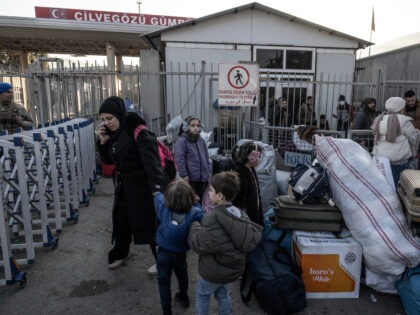 Syrian refugees who live in Turkey wait in a queue with their belongings at Cilvegozu cros