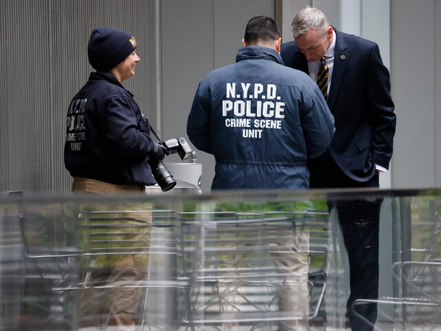 Members of the New York police crime scene unit investigate the scene outside the Hilton H