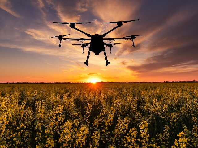 a drone flying as the sun goes down