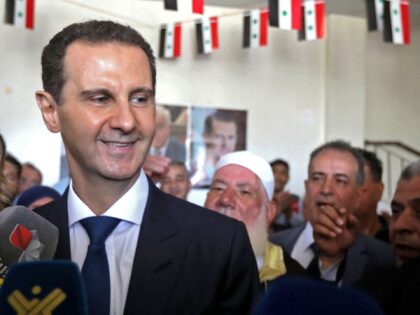 Syrian President Bashar al-Assad greets supporters after casting his vote at a polling sta