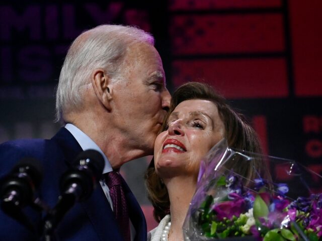 US President Joe Biden kisses honoree House Speaker Emerita Nancy Pelosi onstage during Em