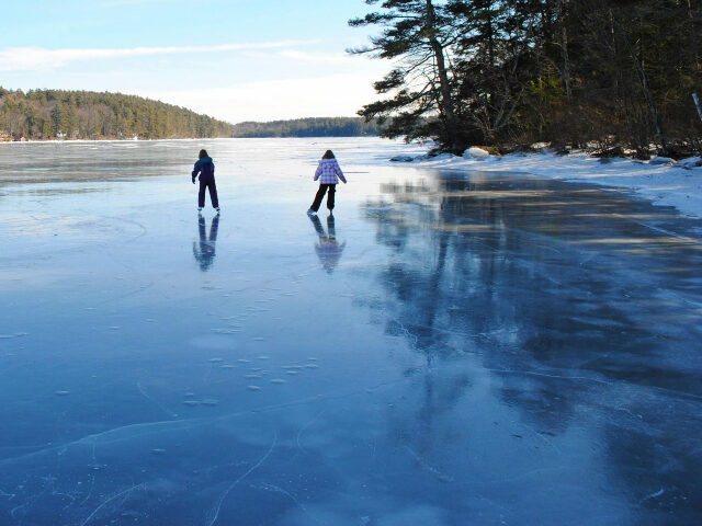 children skating on frozen lake