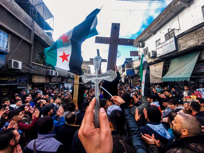 Christian Syrians lift crosses and independence-era flags as they rally in the Duweilaah a