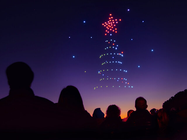 Christmas tree drawn with drone lights in the night sky of Arroyomolinos, Madrid (Spain).