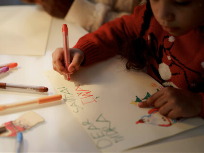 Girl in Red Sweater Making a Christmas Letter