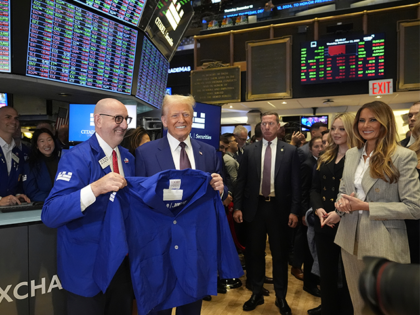 President-elect Donald Trump is handed a coat by trader Peter Giacchi, as he walks the flo