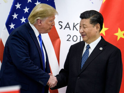 (FILES) In this file photo taken on June 28, 2019, China's President Xi Jinping (R) shakes